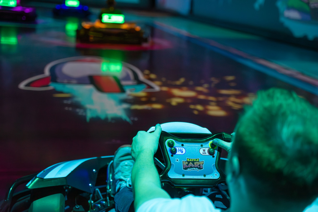 Une personne dans un kart, mains sur le volant, visant un adversaire avec un piège lors d'une partie de BattleRace.